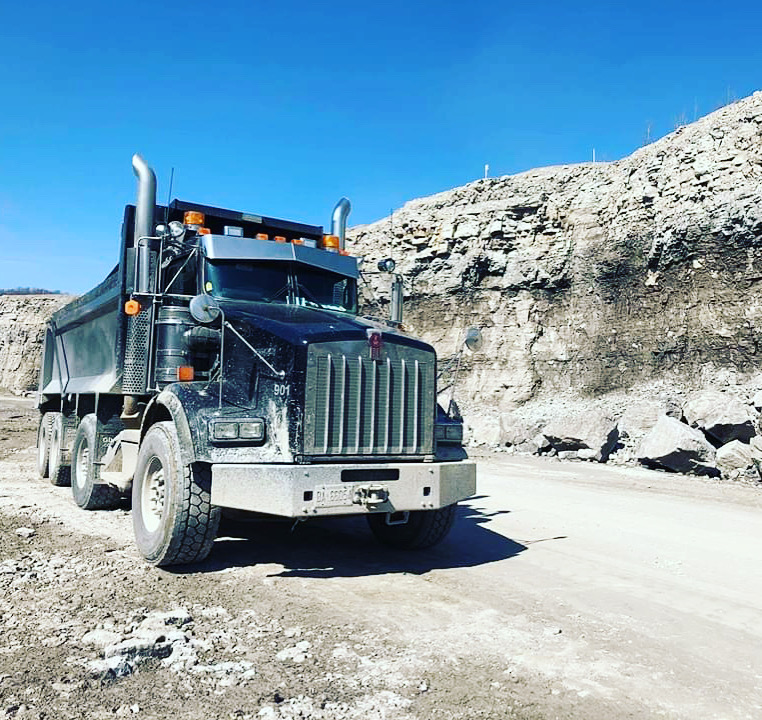 A dump truck driving through a quarry.